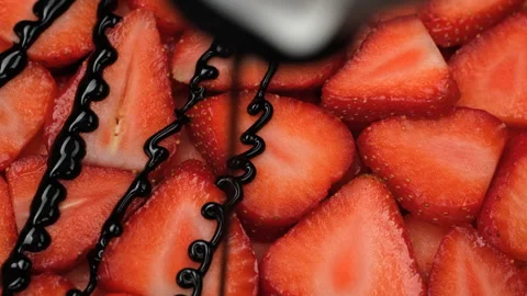Pouring chocolate syrup over slice fresh strawberries Stock Footage 310435904