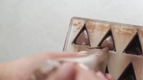 Pouring chocolates in a triangular shape with a filler Stock Footage 132800265