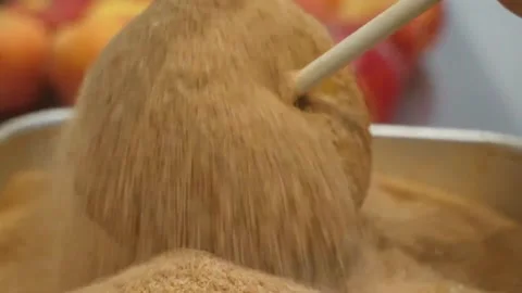 Pouring Cinnamon Sugar Coating on a Sticky Caramel Candy Apple Vídeos de archivo 345292642