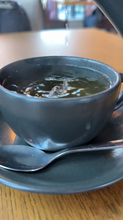 Pouring citrus tea in cup close-up. Fresh hot herbal tea with mint and oranges Stock Footage 323925089
