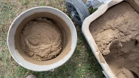 Pouring Clay Mixture into Light Bucket from Above Stock Footage 316539519