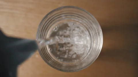 Pouring clean drinking water into a glass. View from above. Stock Footage 268989403