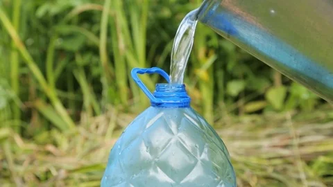 Pouring clean water into the plastic bottle Stock Footage 79671426