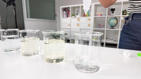 Pouring Clear Liquid Into Glass Beaker in Chemistry Laboratory Stock-Footage 345457888