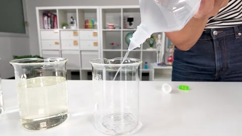 Pouring Clear Liquid Into Glass Beaker in Science Laboratory Stock Footage 345695465