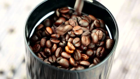 Pouring coffee beans from in a empty coffee bean grinder in slow motion  Stock Footage 229738465