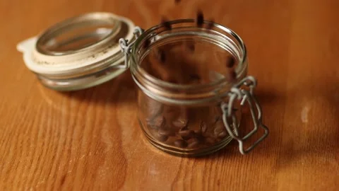 Pouring coffee beans into a jar in slow motion Stock Footage 232482337