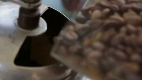 Pouring coffee beans into an old fashioned vintage hand held coffee mill Stock Footage 88238658