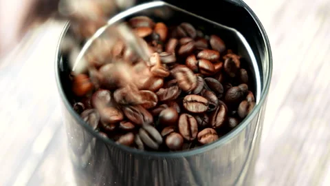 Pouring coffee beans from a side in a half-empty coffee bean grinder in slowmo Stock-Footage 229738044