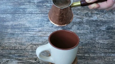 Pouring coffee from cezve into the cup Stock Footage 72331523