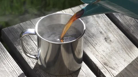 Pouring coffee into a cup outdoors Stock Footage 273774214