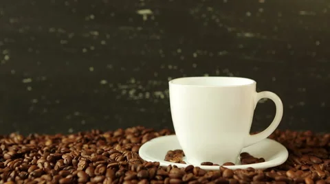 Pouring coffee in cup surrounded by coffee beans Video stock 62468999