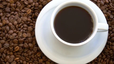 Pouring Coffee In Cup Surrounded By Coffee Beans Vidéo 96424919