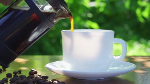 Pouring coffee into cup on the table in the garden scenery Stock Footage 223693182