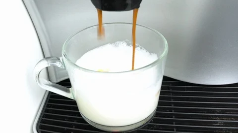 Pouring coffee going out from a coffee espresso machine into a glass cup Stock Footage 105901109