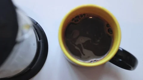 Pouring coffee into a mug with smiley face at the bottom. Reverse speed. Stock Footage 69820699