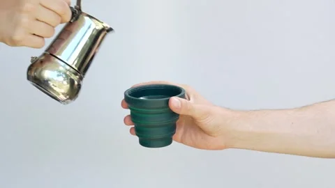 Pouring coffee into plastic, collapsible and reusable coffee cup 動画素材 246129407