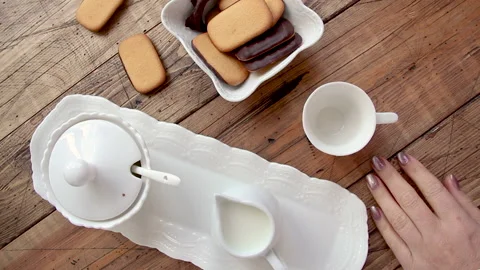 Pouring coffee into a small coffee cup on a wooden table top view Stock Footage 150870072