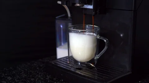 Pouring coffee stream from automatic coffee latte machine in cup. Stock Footage 124900762
