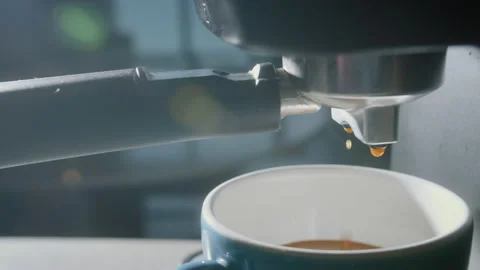 Pouring coffee stream from machine in blue cup. Home making hot Espresso in mug Stock Footage 233935996
