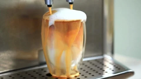Pouring coffee stream from machine in cup. Home making hot Latte. Stock Footage 142642614