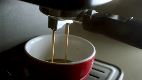 Pouring coffee stream from machine in cup. Home making hot Espresso. Using Stock Footage 246568981
