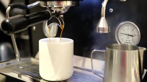Pouring coffee stream from machine in cup. Cafe making hot Espresso. Using Stock Footage 265974009