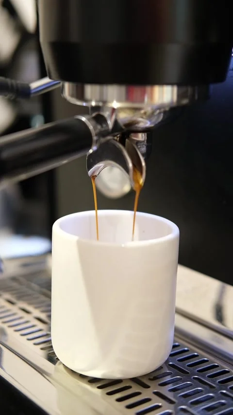 Pouring coffee stream from machine in cup. Cafe making hot Espresso. Using Stock Footage 265974087