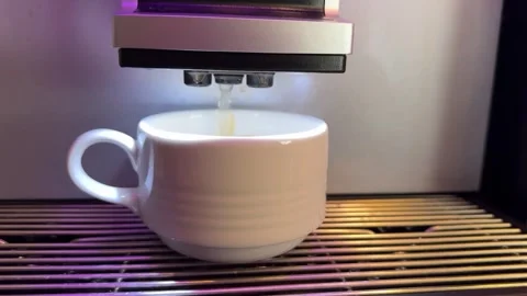 Pouring coffee stream from machine in cup. Home making hot mochaccino. Close-up Stockbeeldmateriaal 299620739