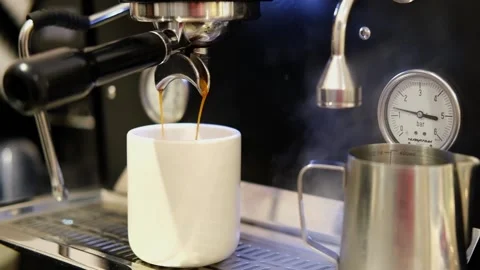 Pouring coffee stream from machine in cup. Cafe making hot Espresso. Using Stock Footage 307301346