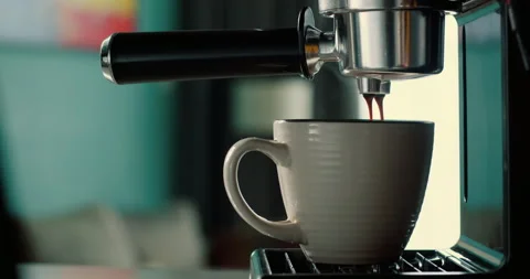Pouring coffee stream from machine into cup. Fresh espresso brewing with filter Stock Footage 317724235