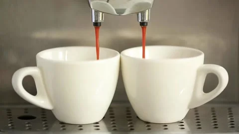 Pouring coffee stream from machine into two cup. Home making hot Espresso. Stock Footage 142510089