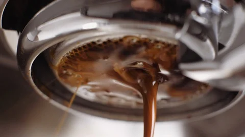 Pouring coffee stream from professional machine in cup. Barista