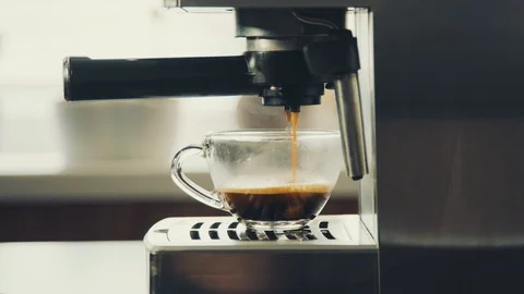 Pouring coffee stream from professional machine in cup Flowing fresh ground coff Stock Footage 126395013