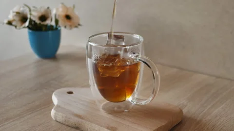 Pouring coffee, tea into a cup with ice. Coffee, tea cold drink with ice Stock Footage 158061934