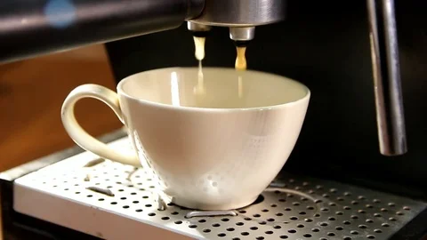 Pouring coffee into a white cup from the nozzle of a coffee machine Stock Footage 84275029