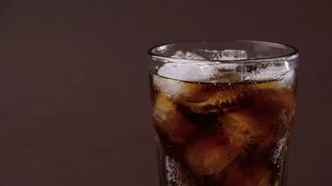 Pouring cola drink with ice cubes close-up. Stock Footage 274090699