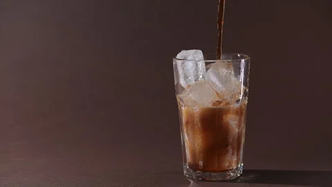 Pouring cola drink with ice cubes close-up. Video stock 274091680