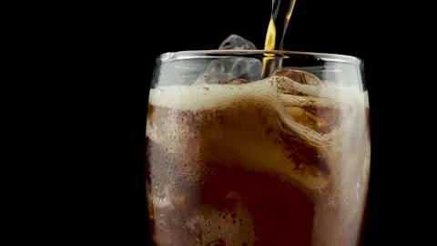 Pouring cola into glass with ice while rotating Stock Footage 233394379