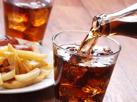 Pouring cola in glass Stock Photos