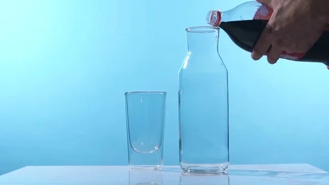 Pouring cola into a glass on a table in a clean, studio environment. Shot in slo Stock Footage 74825520