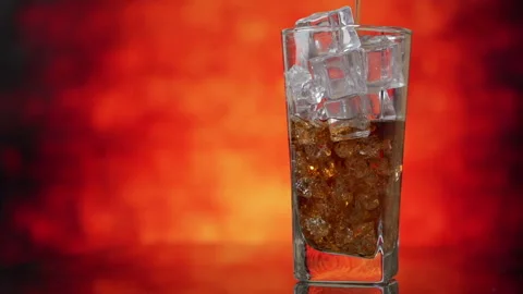 Pouring Cola with ice cubes close-up. Cola with Ice and bubbles in glass. Stock Footage 130460932