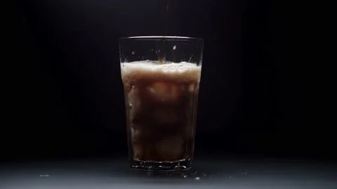 Pouring Cola with ice cubes close-up. Cola with Ice and bubbles in glass. Coke Vídeo Stock 148169277
