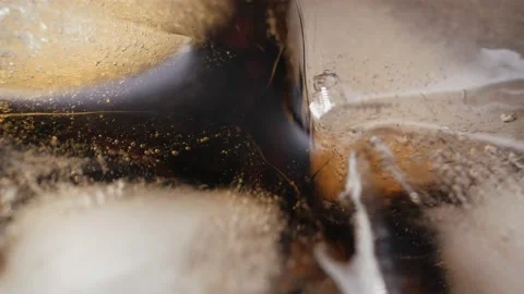 Pouring Cola with ice cubes close-up. Cola with Ice and bubbles in glass. Stock Footage 155245090