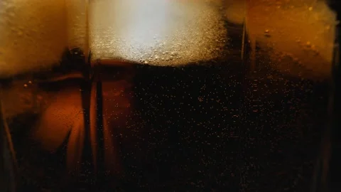 Pouring Cola with ice cubes close-up. Cola with Ice and bubbles in glass. Stock Footage 159909240