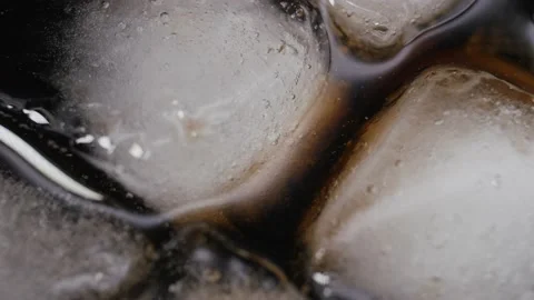 Pouring Cola with ice cubes close-up. Cola with Ice and bubbles in glass. Stock Footage 160768868