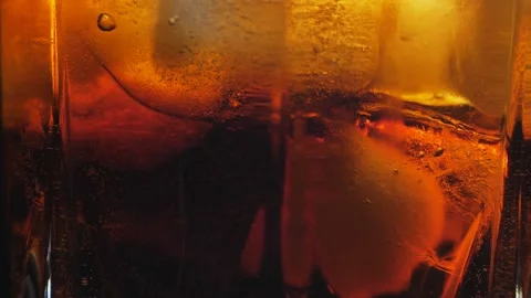 Pouring Cola with ice cubes close-up. Cola with Ice and bubbles in glass. Stock-Footage 161270403