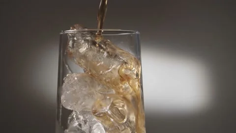 Pouring Cola with ice cubes. Cola with Ice and bubbles in glass. Stockbeeldmateriaal 180455197