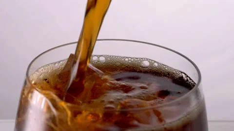 Pouring Cola with ice cubes. Cola with Ice and bubbles in glass. Stock Footage 231034965