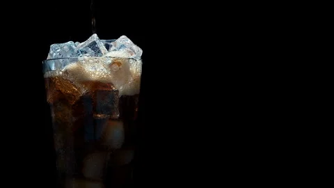 Pouring Cola Soda Over Ice Cubes in Glass, Black Background Stock Footage 346087988